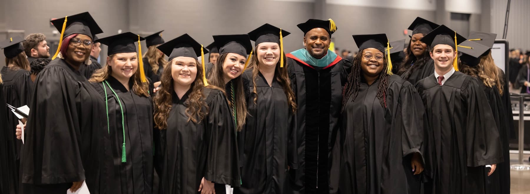 Eight UMMC Graduates pose for a photo at Commencement